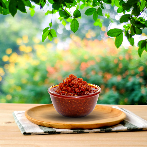 A bowl of homemade prawn pickle, a fusion of seafood and spices, perfect for savory cravings.