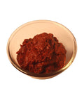 A traditional Indian condiment, tomato pickle, exhibiting a mix of savory spices and tomato chunks.